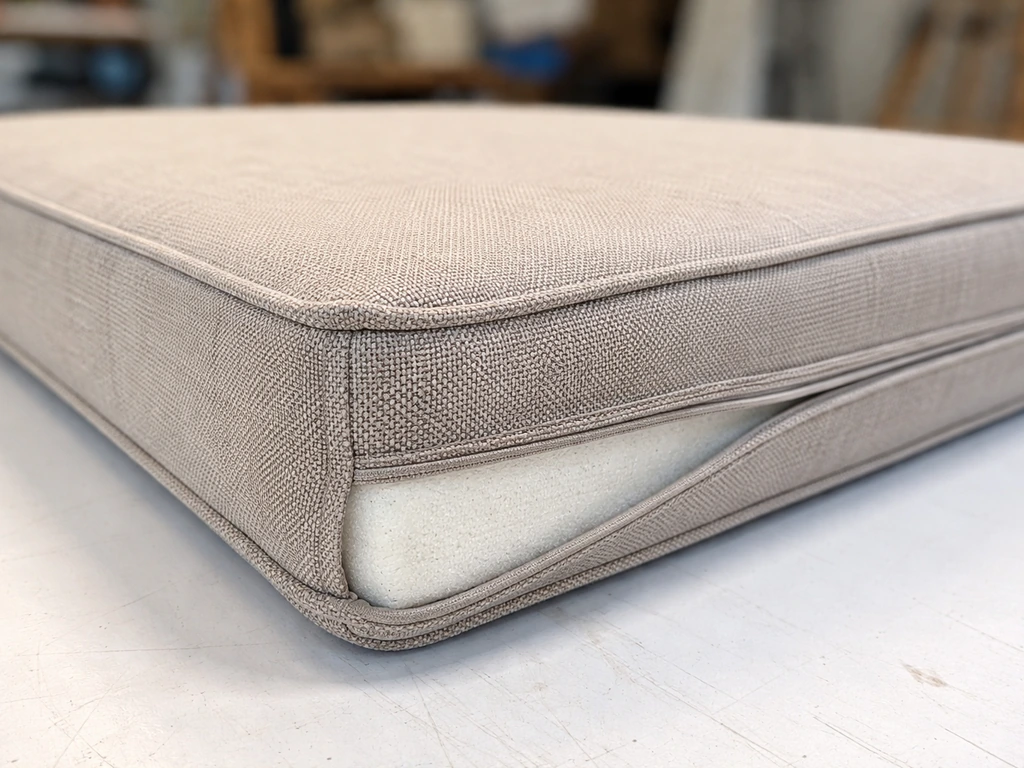 Close-up of an outdoor cushion showing solution-dyed acrylic fabric texture and foam thickness