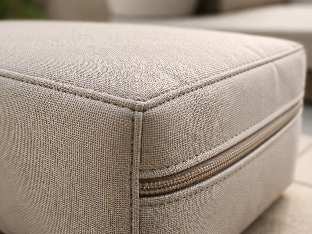 Close-up of outdoor cushion fabric with visible stitching and zipper detail, showing durable texture.